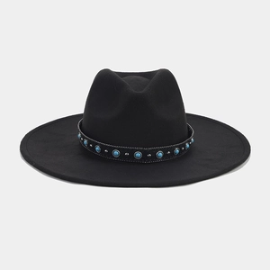Detail of black fedora hat with turquoise beads and silver studs on a western band