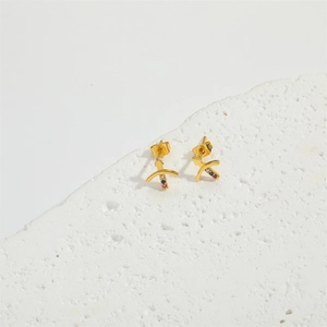 Gold Sagittarius archer arrow stud earrings with colorful gemstones on white stone