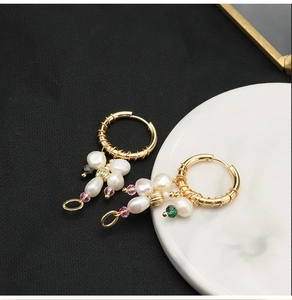 Detailed view of baroque pearl drop earrings with colorful beads on gold hoops