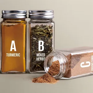 Three square glass spice jars with silver metal lids showing various colored powders