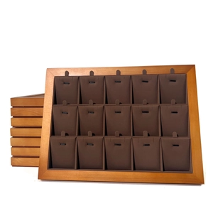 Detail of walnut wood jewelry tray with 15 slots and dark brown velvet for necklaces