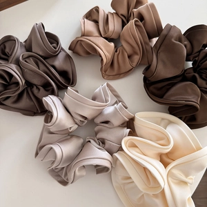 Set of large satin scrunchies in earth tones featuring elegant glossy fabric texture