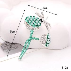 Macro detail of 5cm silver alloy sunflower brooch with green rhinestones and pearls