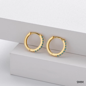 Detail view of 9mm gold-plated sterling silver hoop earrings with inlaid turquoise beads
