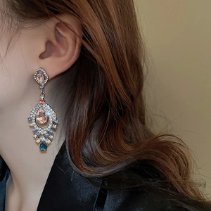 Detailed view of vintage palace style earrings with pink teardrop stones and crystals