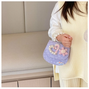 Detail of purple girl's handbag with pearl handle, 3D flower and heart jewel decoration
