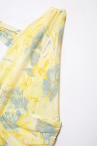 Detailed close-up of yellow floral mesh fabric with sheer texture and blue-grey leaves