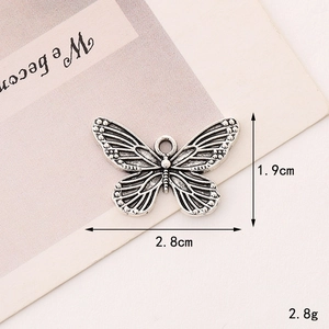 Macro shot of silver butterfly pendant with detailed engravings and size measurements