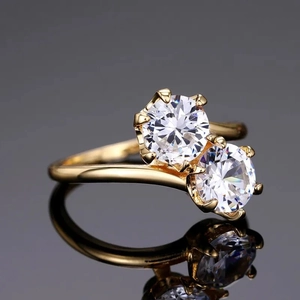 Macro shot of a gold bypass ring with two round-cut brilliant cubic zirconia stones