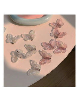 Vue détaillée de dix pinces à cheveux papillon irisées en blanc translucide et rose