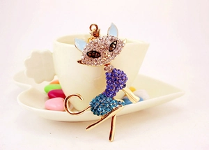 Detailed close-up of a golden cat brooch with purple and blue sparkling rhinestones