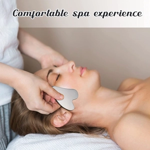 Close-up of heart-shaped stainless steel Gua Sha tool for professional facial spa therapy