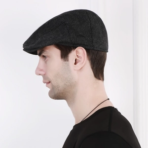 Side view of men's dark grey herringbone flat cap on model showing retro silhouette