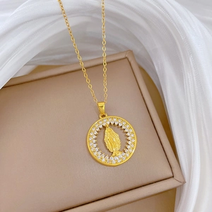 Detail of gold titanium necklace featuring a Virgin Mary pendant with sparkling crystals
