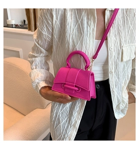 Fuchsia fanny-mini bag with lychee leather texture worn crossbody by model in home setting