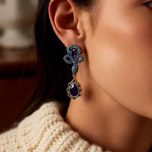 Vintage gold teardrop earrings with purple crystals and fine blue beads detailing