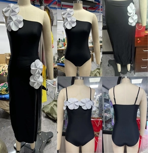 Detail of black one-shoulder swimsuit with white 3D flower and matching long skirt set