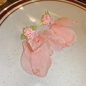 Elegant pink fabric flower earrings with delicate seed beads and soft green leaf accents