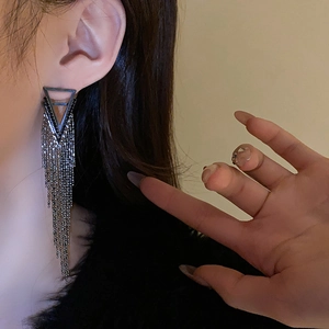 Close-up of silver triangle tassel earrings with sparkling rhinestones on model
