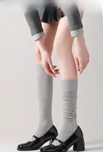 Détail de chaussettes hautes grises en coton côtelé portées avec des chaussures Mary Jane