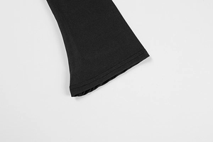 Detail eines eleganten schwarzen Glockenärmels am Strickkleid mit hochwertiger Stofftextur