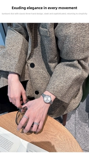 Elegant women's watch with rhinestone bezel and silver dial on textured tweed sleeve