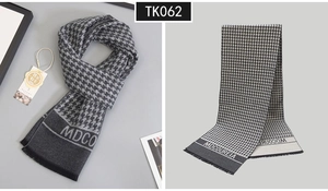 Detail of grey wool cashmere scarf featuring classic houndstooth pattern and soft tassels