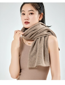 Detailed view of a soft brown cashmere knit shawl scarf draped on a model