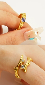 Macro detail of gold irregular lava ring and coral branch style band with purple crystal