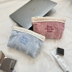 Detailed embroidery of 'Shine Like the Stars' text on velvet travel cosmetic pouches