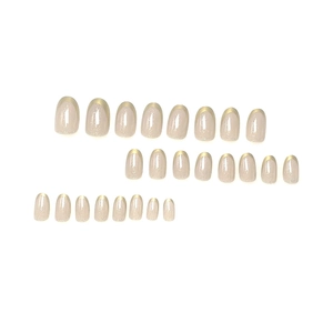 Short oval press-on nails in nude pink glitter finish with elegant gold French tips