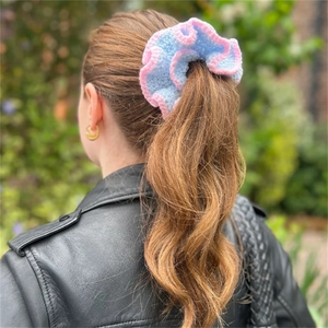 Pink and blue ruffle crochet scrunchie worn on a high ponytail for a vintage summer look