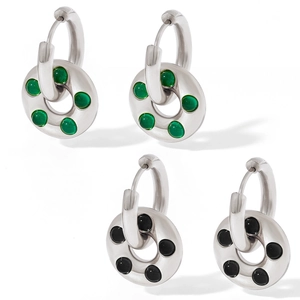 Detail of silver stainless steel hoop earrings with green and black glass donut pendants