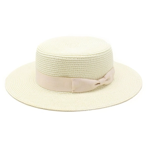 Close-up of beige flat top straw hat featuring a stylish satin ribbon bow detail