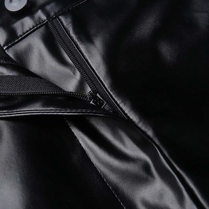 Dettaglio degli shorts in ecopelle nera a vita alta con cerniera e chiusura a bottone