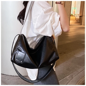 Rückansicht der schwarzen Leder-Pillows-Tasche getragen von einem Model