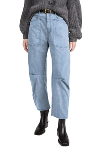 Detail of high waist light blue denim cargo pants with large patch pockets and topstitching