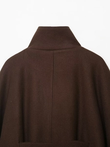 Detail view of the high-quality dark brown wool coat collar and vertical back stitching