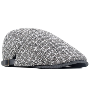 Dettaglio del cappello in tweed con cinturino in pelle laterale e fibbia in bronzo