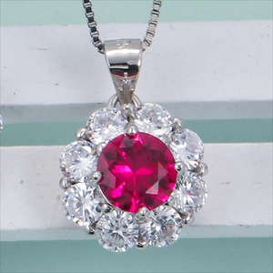 Silver halo necklace featuring a vibrant red round gemstone surrounded by white crystals