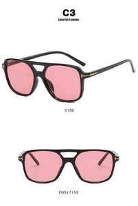 Detail view of T-shaped gold hardware on black aviator sunglasses with pink lenses