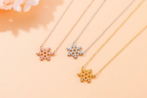 Delicate snowflake pendant necklaces shown in rose gold, silver, and gold finishes