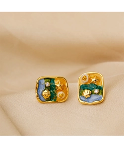 Detailed view of starfish pearl earrings with vintage enamel and gold shell accents