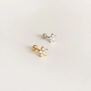 Detailed view of sterling silver star-shaped ear studs with zircons in gold and silver finish
