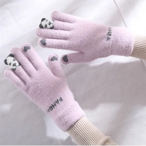 Detailed view of women pink knitted gloves with cute panda finger design and warm wool fabric.