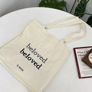 Detail of cream canvas tote bag with beloved embroidery and wide shoulder straps