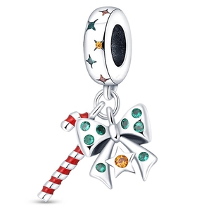 Macro shot of silver candy cane charm with red stripes and green bow gemstone detail
