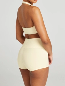 Side view of beige halter neck top and high-waisted shorts set on a studio model