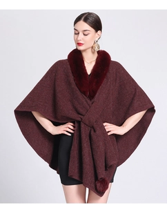 Detail of burgundy knit shawl with faux rabbit fur collar and decorative pom-poms