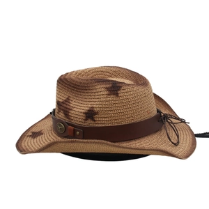 Dettaglio del cappello da cowboy in paglia con motivi a stelle e fascia in cuoio vintage